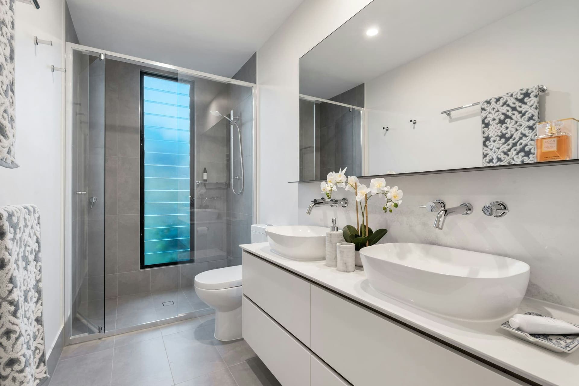 Lichte badkamer met douche, toilet en dubbele wastafel